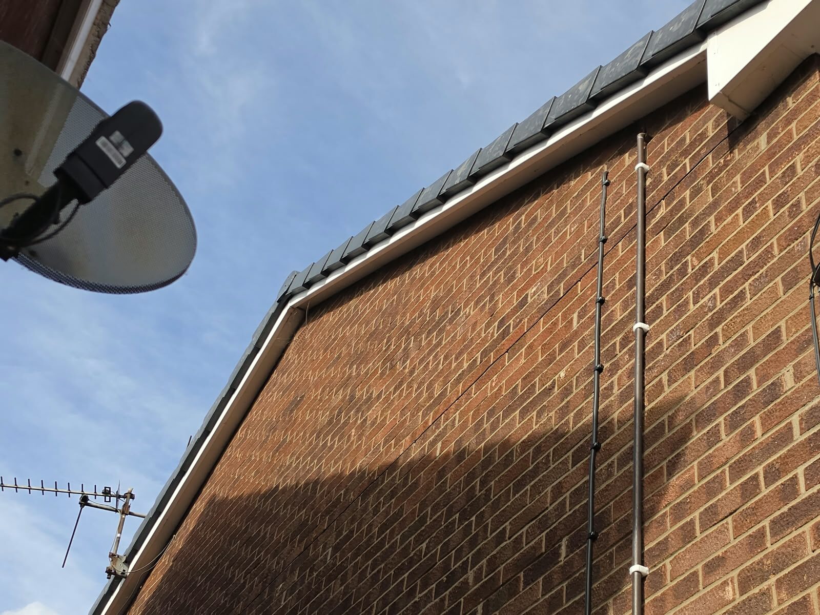 Long run of grey dry verge caps and clean white fascia along the roof edge of a brick house in Doncaster